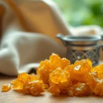 Les cristaux de myrrhe brillent sur une surface en bois, évoquant l'arôme et la beauté.